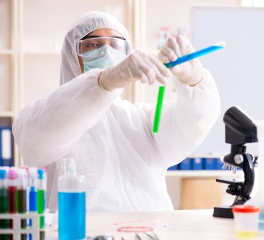 Laboratuvarda çalışan genç yakışıklı kimyager.