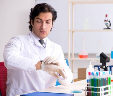 Laboratuvarda çalışan genç yakışıklı kimyager.