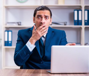 Genç yakışıklı işadamı ofiste çalışıyor.