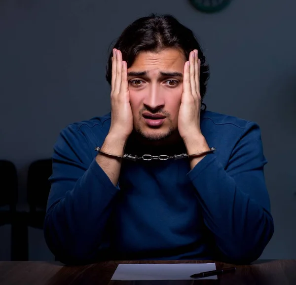 Young convict man sitting in dark room — Stock Photo, Image