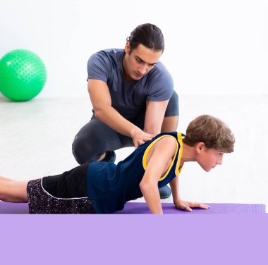 Genç baba ve oğlu egzersiz yapıyor.