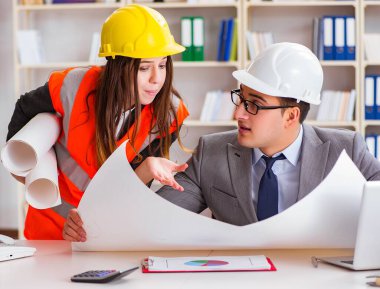 İnşaat ustabaşı çizimleri gözden geçiriyor