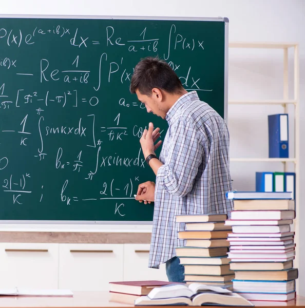 O jovem estudante do sexo masculino estudando matemática na escola — Fotografia de Stock