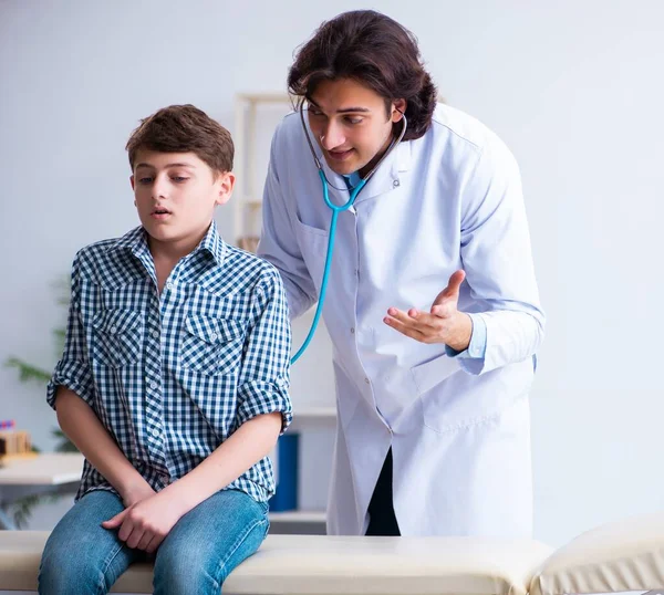 Médico varón examinando niño por estetoscopio —  Fotos de Stock