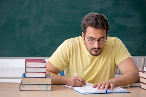 Joven estudiante masculino preparándose para los exámenes en el aula — Foto de Stock