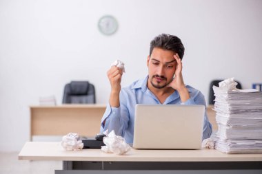 Genç bir erkek çalışan ofiste yeni fikirleri reddediyor.