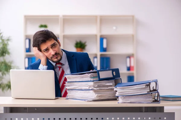 Jovem funcionário masculino infeliz com excesso de trabalho no escritório — Fotografia de Stock