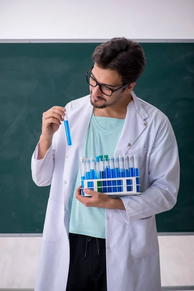 Junger Chemiker vor der Tafel — Stockfoto