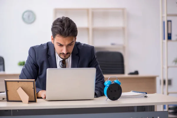 Jonge knappe werknemer in tijdmanagementconcept — Stockfoto