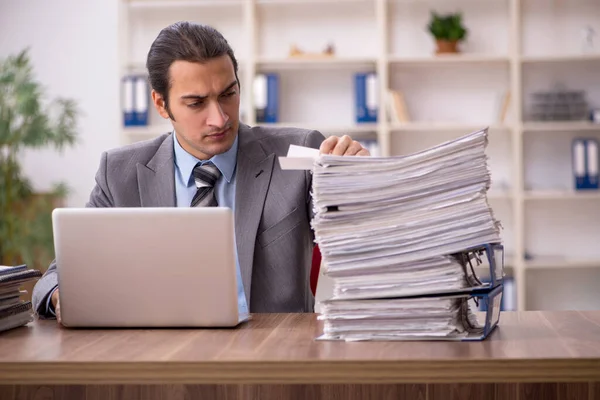 Jovem funcionário masculino infeliz com excesso de trabalho no escritório — Fotografia de Stock