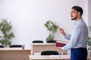 Sınıftaki genç erkek öğretmen.