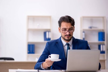 Molada kahve içen genç bir erkek.