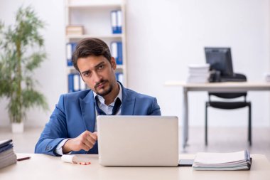 İş yerinde acı çeken genç bir erkek işçi.