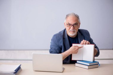 Sınıftaki yaşlı erkek öğretmen.