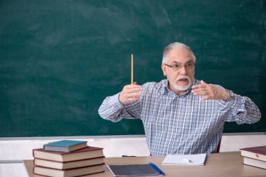 Sınıftaki yaşlı erkek öğretmen.