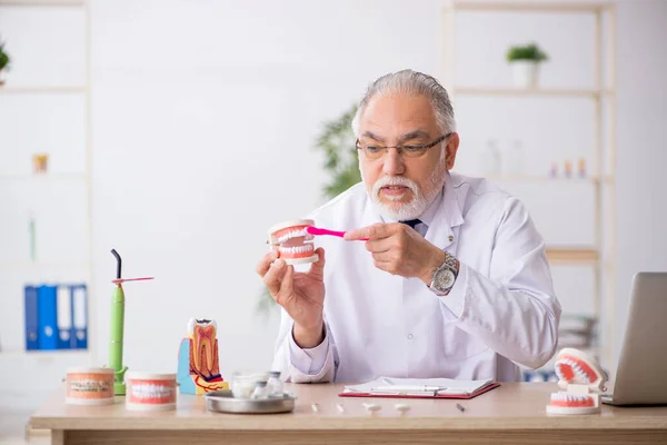 Viejo médico dentista que trabaja en la clínica — Foto de Stock