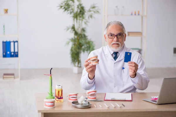 Klinikte çalışan yaşlı erkek dişçi. — Stok fotoğraf