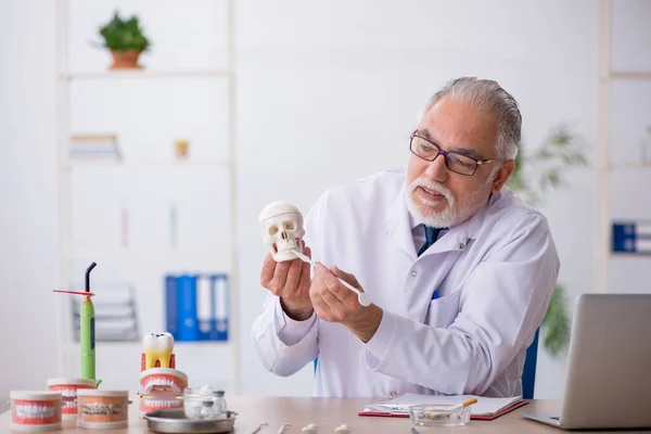 Klinikte çalışan yaşlı erkek dişçi. — Stok fotoğraf