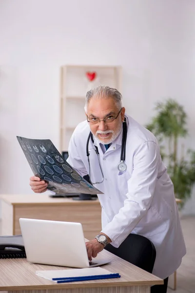 Starý lékař radiolog pracující na klinice — Stock fotografie