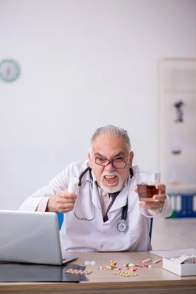 Oude mannelijke arts werkt in het ziekenhuis — Stockfoto