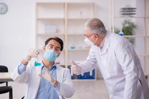 Dwóch chemików pracujących w laboratorium podczas pandemii — Zdjęcie stockowe