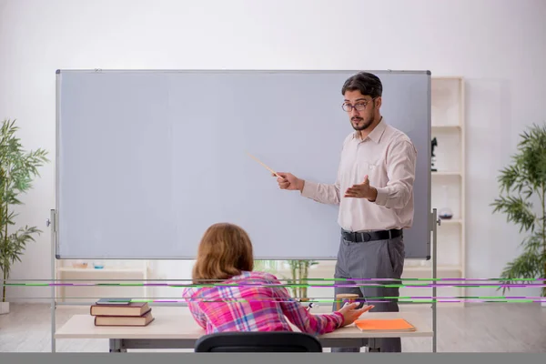 Jong man leraar en roodharige meisje in de klas — Stockfoto