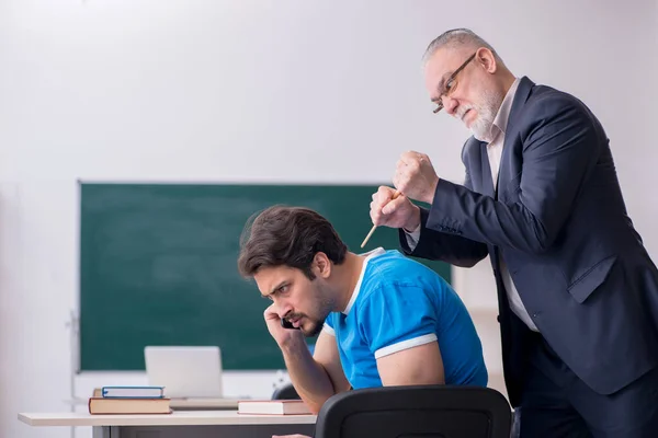 Gammal manlig lärare och ung telefonmissbrukare student i klassen — Stockfoto