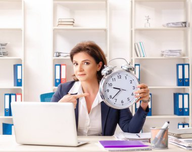 Ofiste oturan orta yaşlı bayan çalışan.