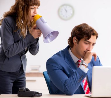 İşitme cihazı kullanan sağır işçi patronla konuşuyor.