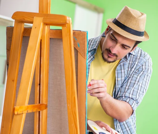 Joven artista masculino trabajando en una nueva pintura en su estudio — Foto de Stock