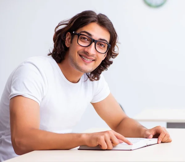 Jonge mannelijke student zit in de klas — Stockfoto