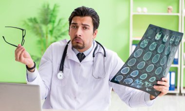 Doktor radyoloji uzmanı hastanede röntgen taramasına bakıyor.