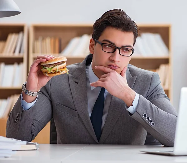 空腹面白いビジネスマンがジャンクフードサンドイッチを食べる — ストック写真