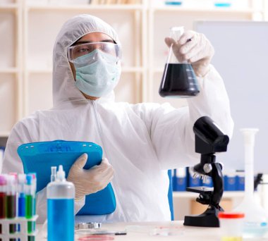 Laboratuvarda çalışan genç yakışıklı kimyager.