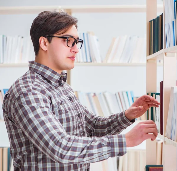 Fiatal diák keres könyveket főiskolai könyvtár — Stock Fotó