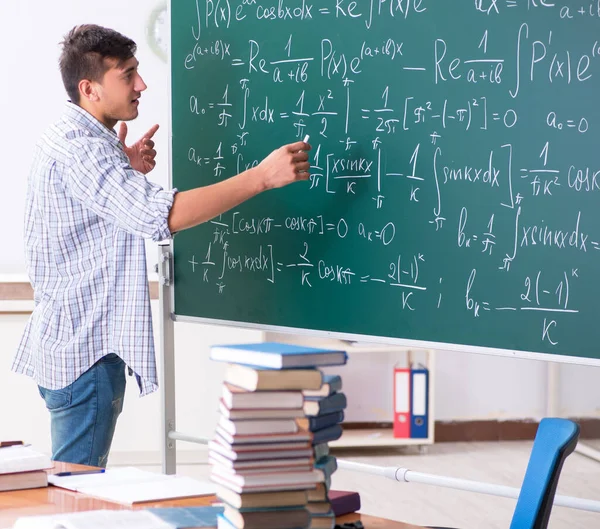 O jovem estudante do sexo masculino estudando matemática na escola — Fotografia de Stock