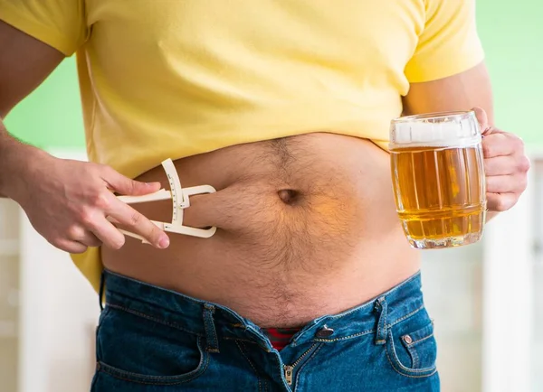 Fet överviktig man som håller öl i bantningskoncept — Stockfoto