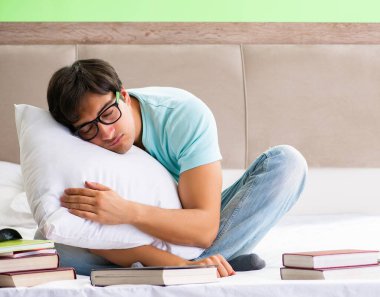 Sınavlara hazırlanan öğrenci yatak odasında oturuyor.