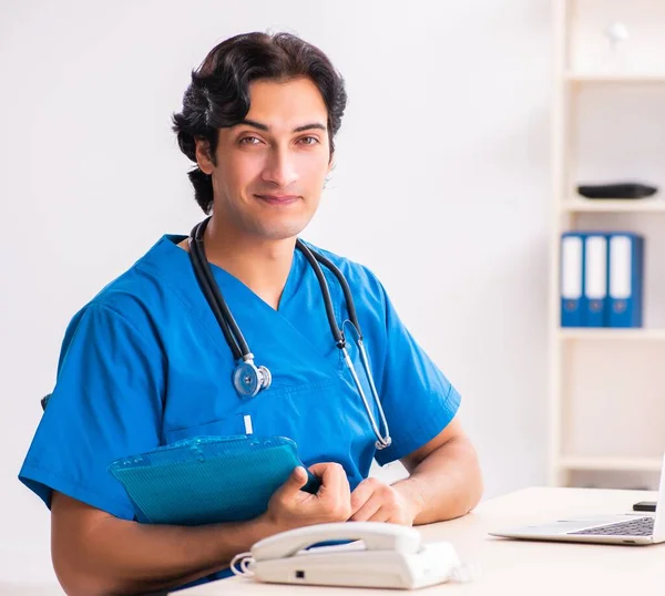 The young handsome doctor working at the clinic — Stock Photo, Image