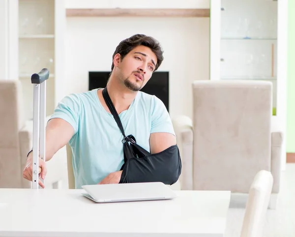 Homem ferido com muletas sentado em casa — Fotografia de Stock