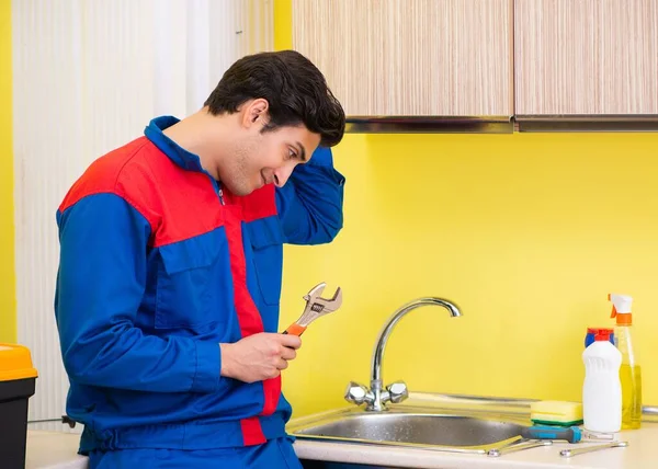 Plumber repairing tap at kitchen — Stock Photo, Image