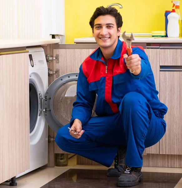 Tamirci mutfakta çamaşır makinesini tamir ediyor. — Stok fotoğraf