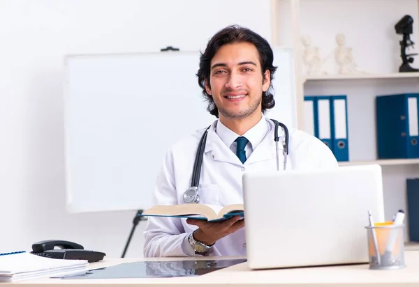 The young handsome doctor working in clinic — Stock Photo, Image