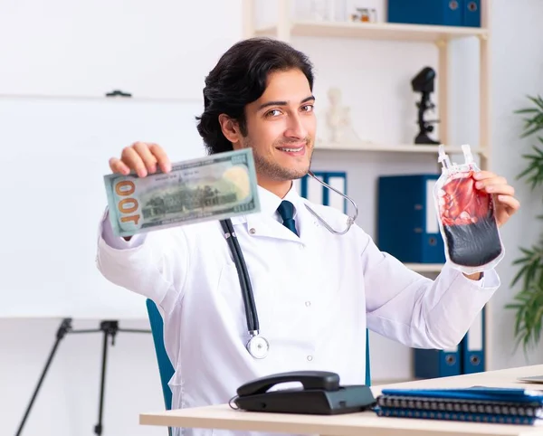 O jovem médico bonito no conceito de transfusão de sangue — Fotografia de Stock