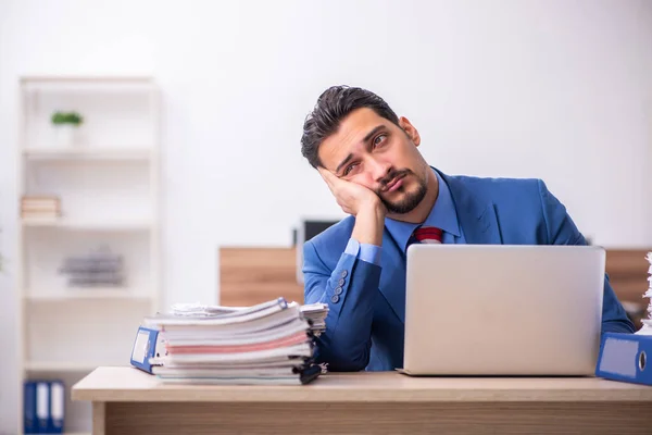 Jovem trabalhador masculino infeliz com excesso de trabalho no local de trabalho — Fotografia de Stock