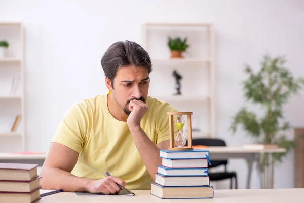 Jeune étudiant de sexe masculin se préparant à des examens en gestion du temps concéder — Photo