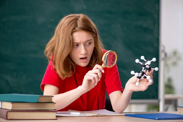 Jonge vrouwelijke student chemicus voorbereiding voor examens in de klas — Stockfoto