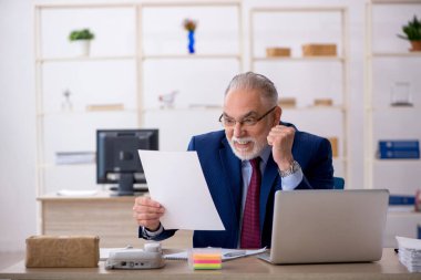 Ofiste çalışan yaşlı bir erkek.