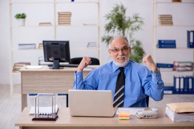 Ofiste çalışan yaşlı bir erkek.