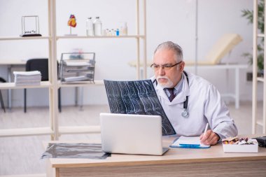Klinikte çalışan yaşlı bir erkek radyolog.